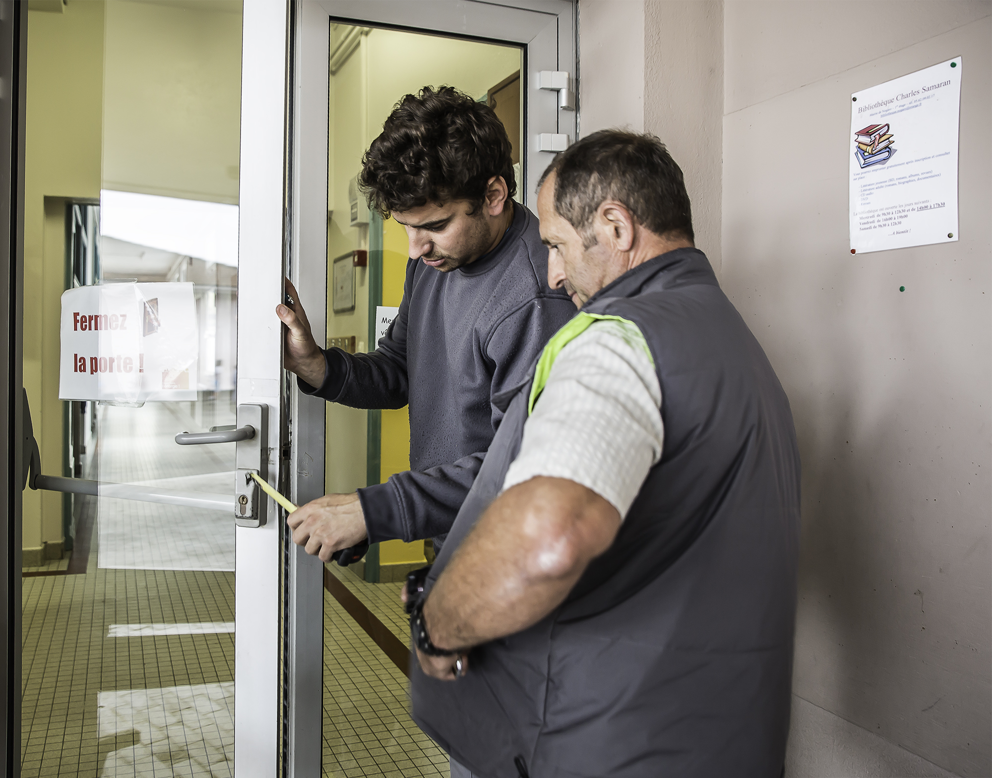 Michel Clavé et un collègue examinent la porte de l'école 1bis 121015.jpg