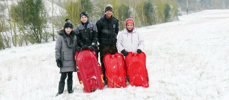 Heureux de glisser avec leur luge tout près de leur village