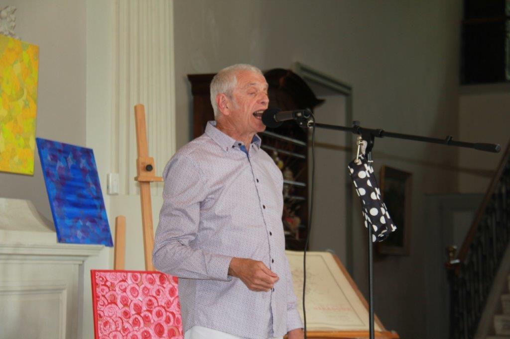 Pierre chantant devant les peintures de Corinne Bobier