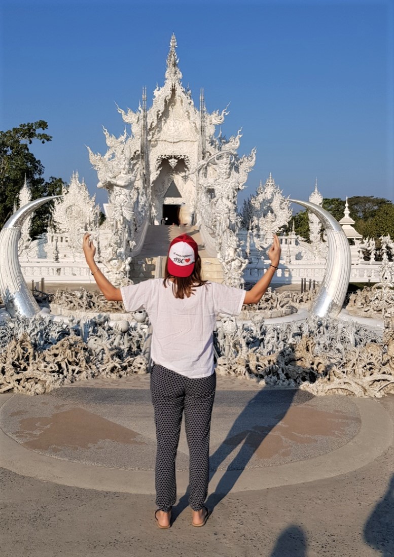Lucie et sa casquette ABC devant le temple Wat Rong Khun en Thaïlande.