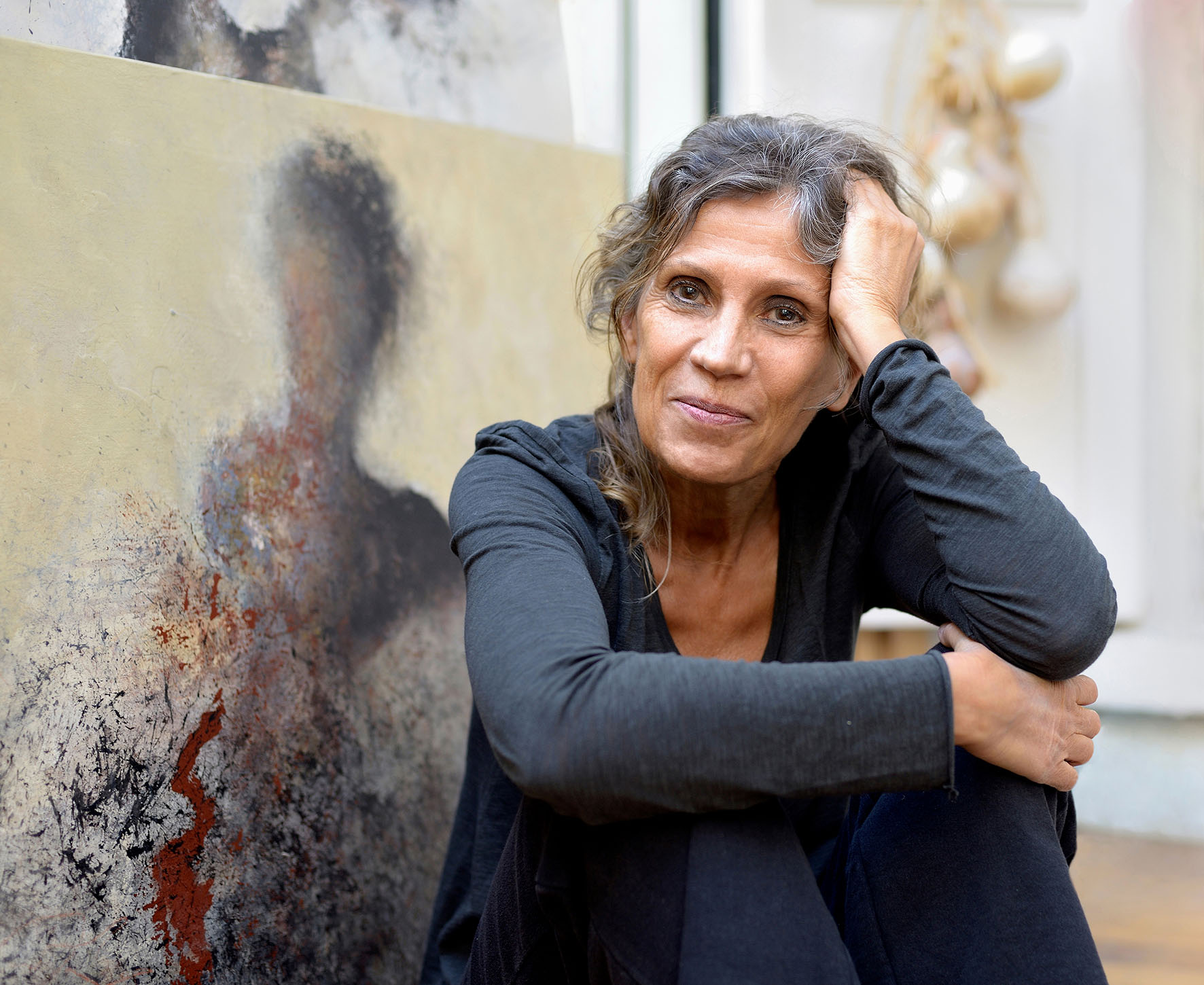 L'artiste devant une de ses toiles