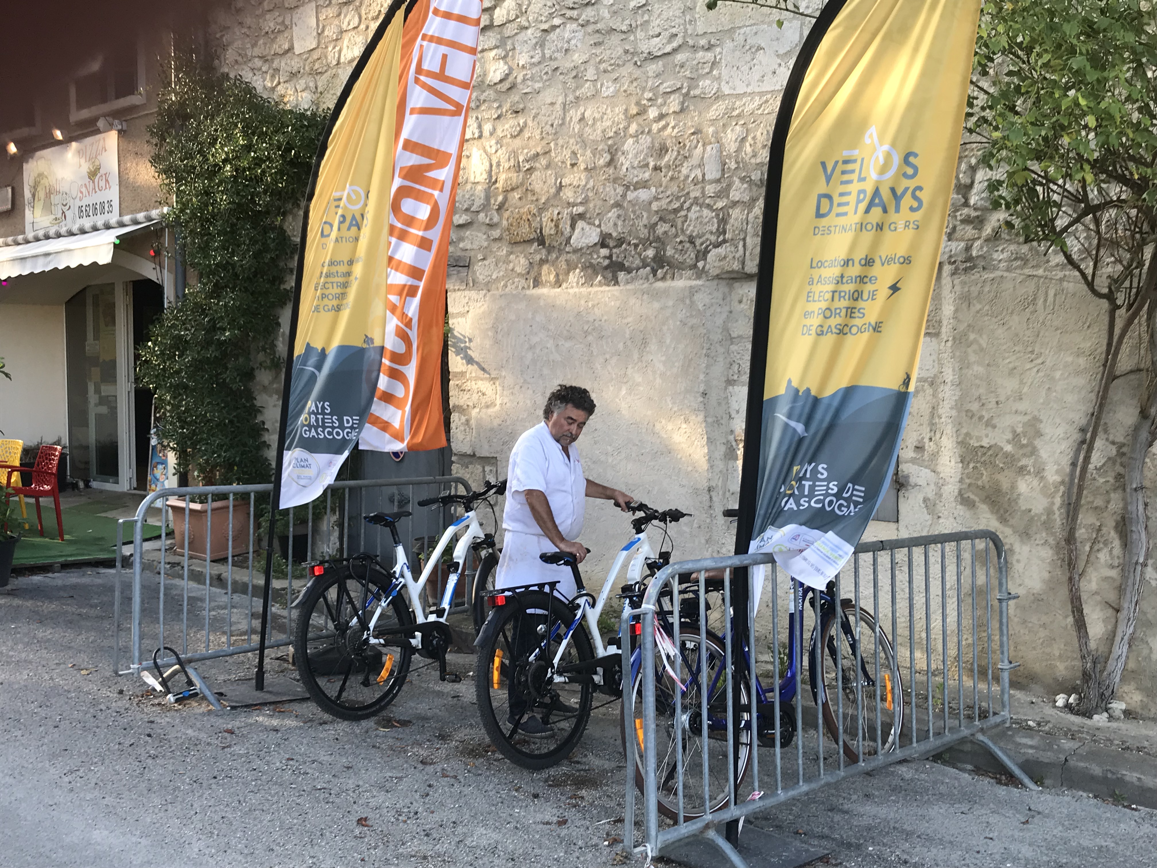Philippe du snack l'Aïoli devant les vélos électriques