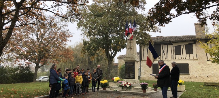 Devant le monument aux morts, le maire de Pauilhac M. Suarez, M. Claude Menegazzo et les enfants de l'école avec les époux Delmas.