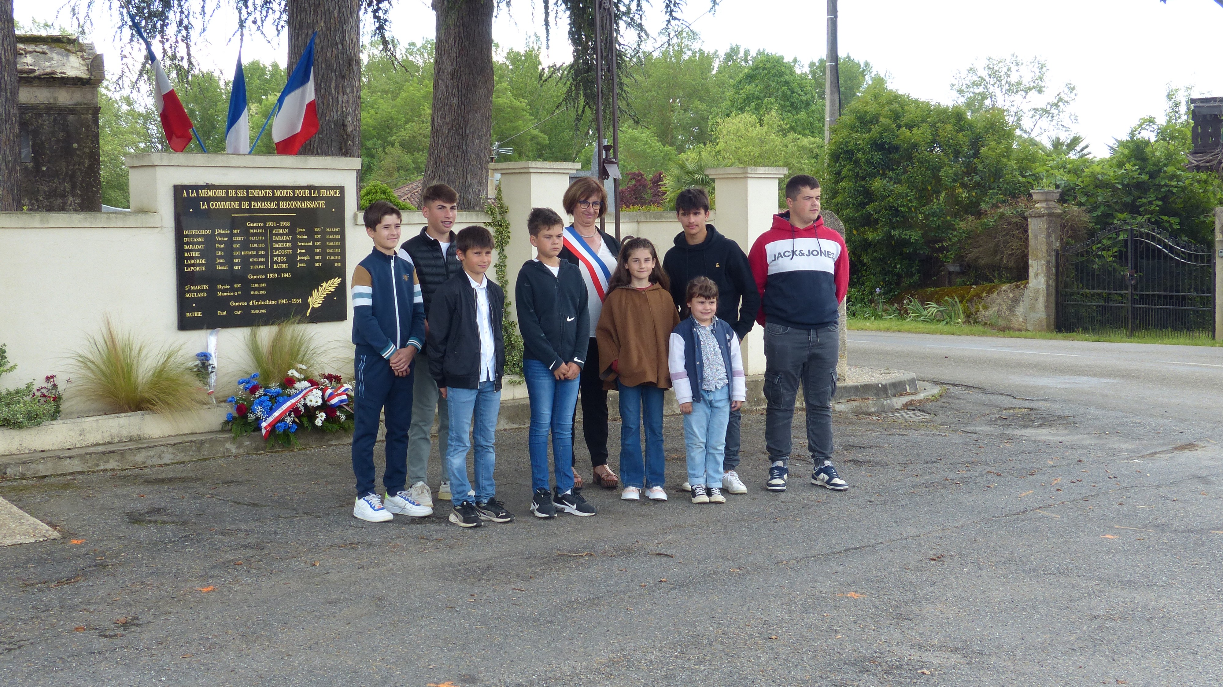 Les jeunes et Madame  le Maire devant la nouvelle plaque