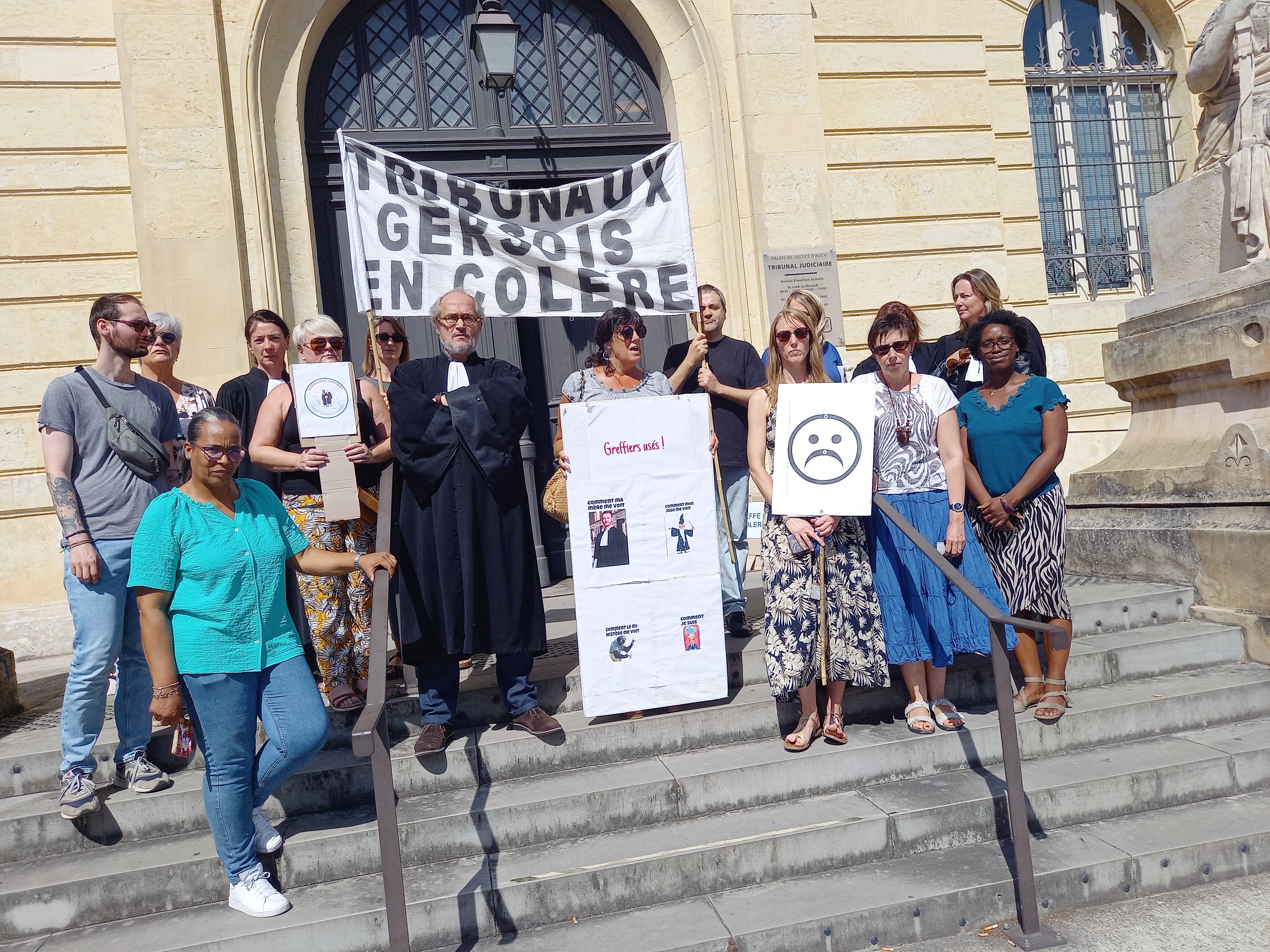 Greffiers et magistrats devant le palais de justice.