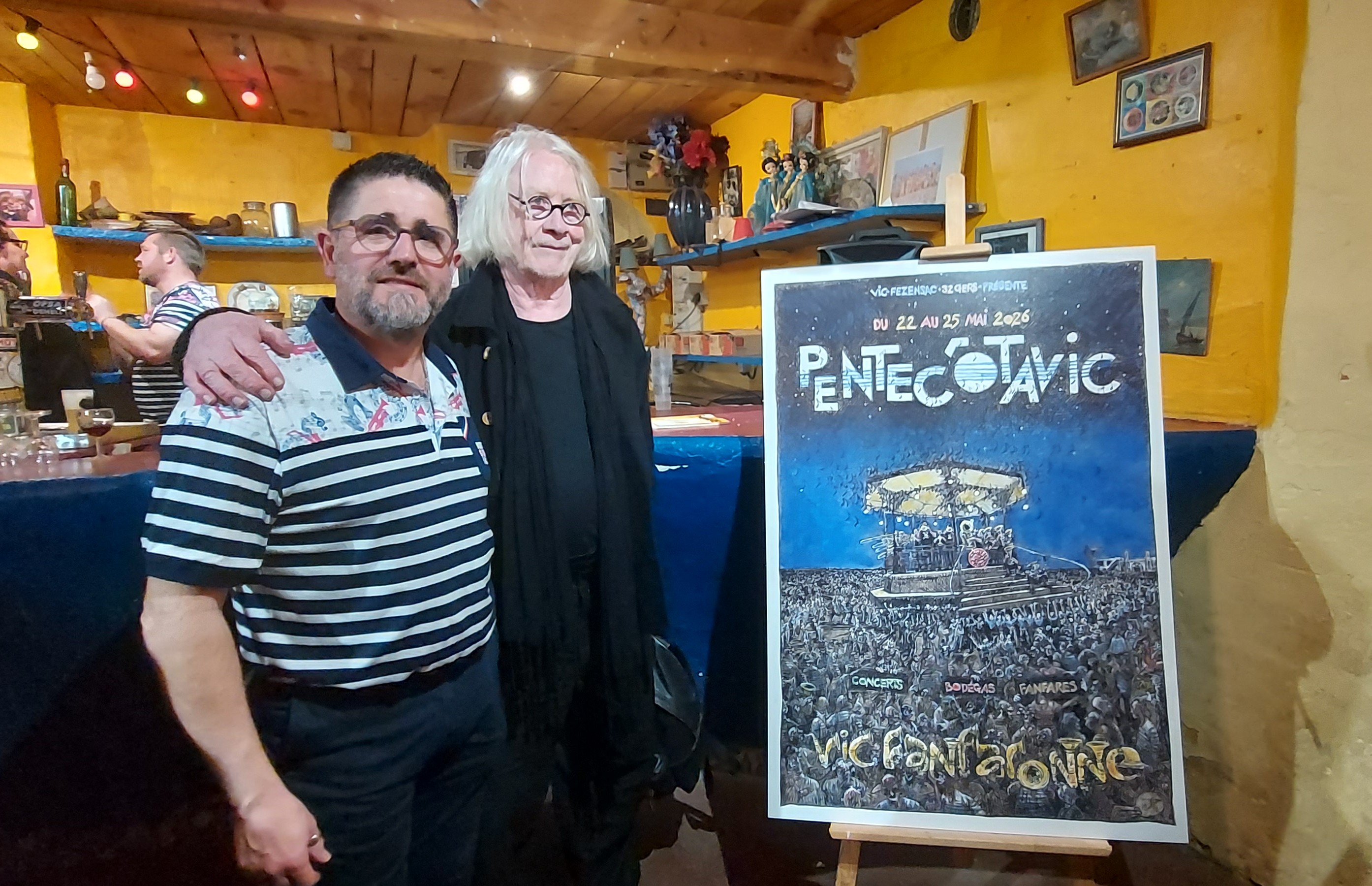 Le président Pascal Lamothe et le dessinateur Jy à côté de l'affiche 2026